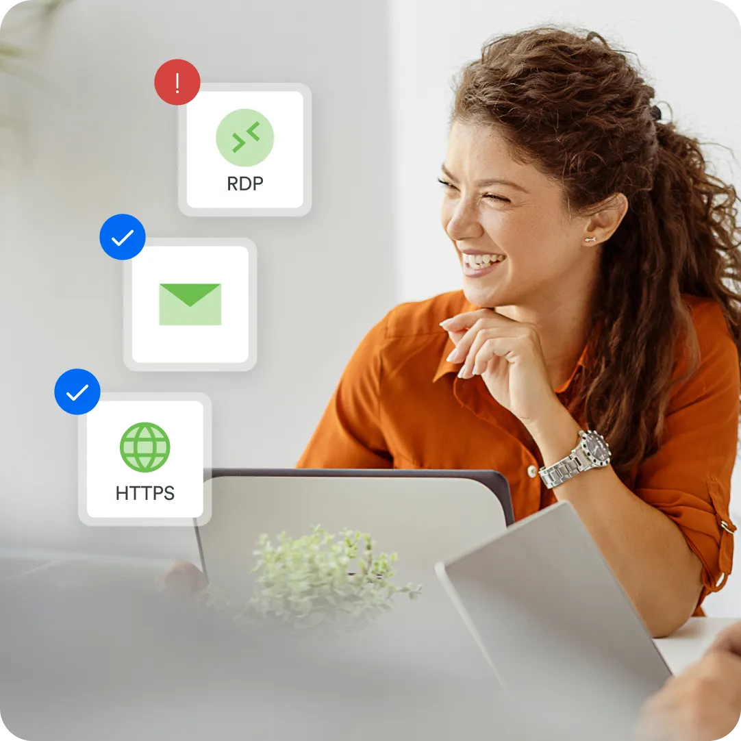 Smiling professional at laptop showing relief that permissions are tailored within applications in Duo without extra effort due to Duo's access policy.