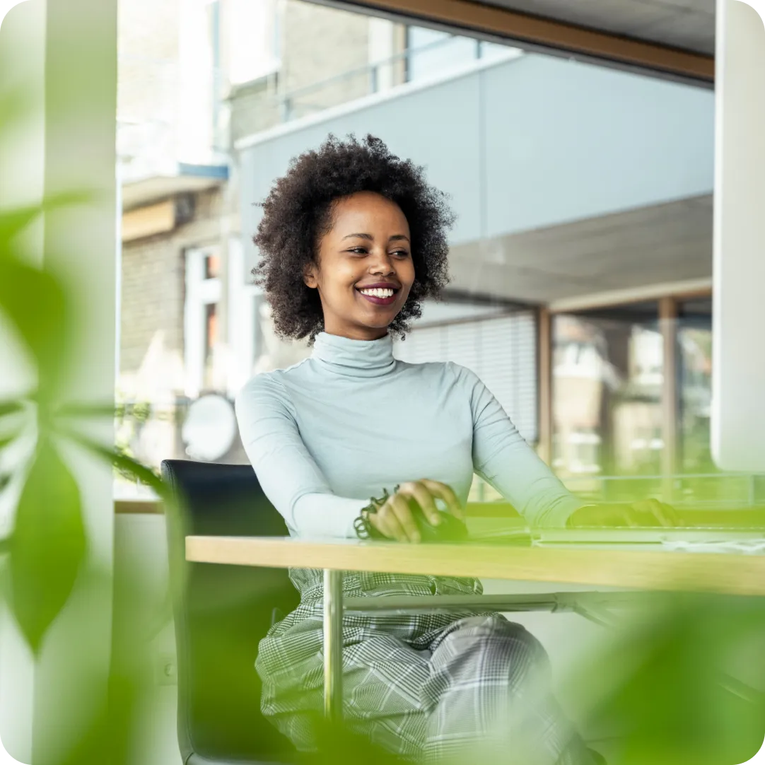 Smiling professional using Duo at their desk, showcasing a positive experience with secure identity access and a 30-day free tiral of Duo