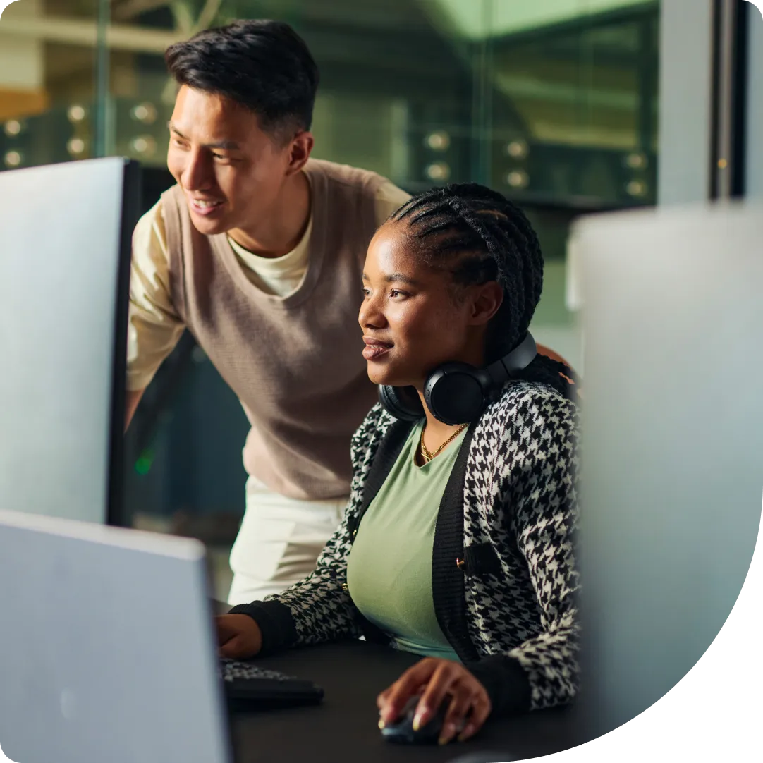 Two professionals collaborating at a computer, showcasing Duo setup support and deployment guidance.